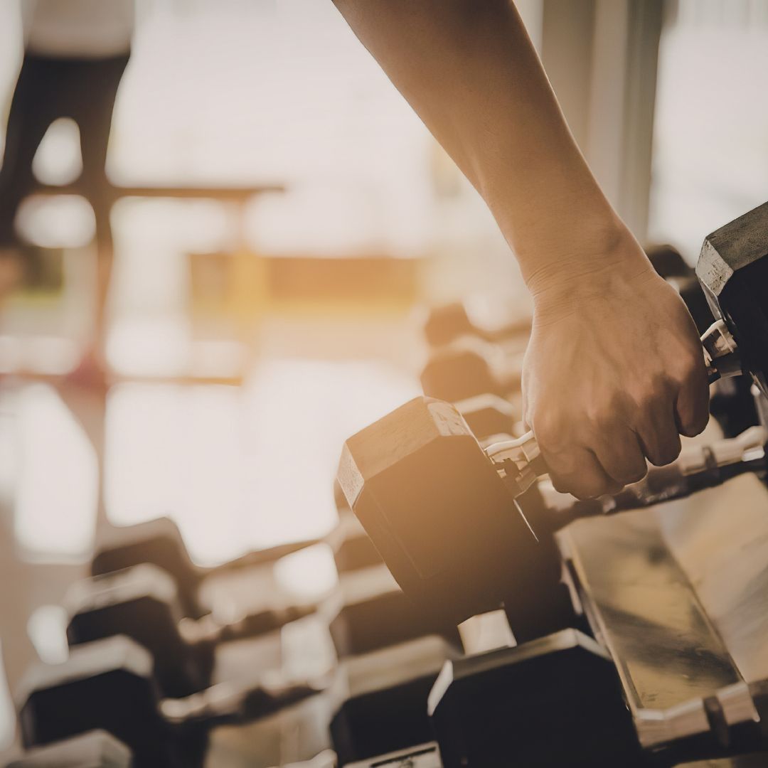 Woman performing strength training exercises to support muscle and metabolic health in PMOS.
